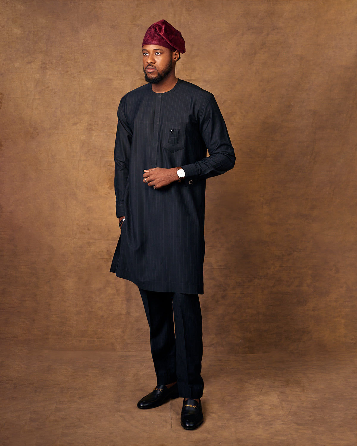 MAn in Navy blie Nigerian traditionla wearwith a Burgundy vevlet yoruba cap